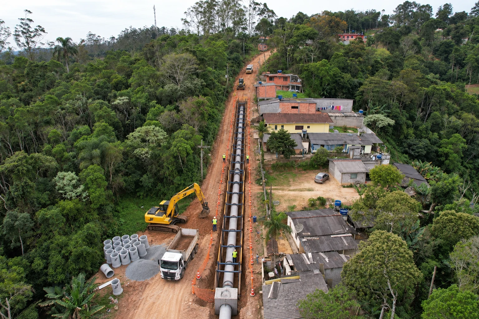 Obra de drenagem com instalação de tubulação e equipe em campo